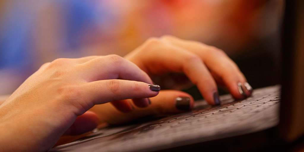 Closeup of hands typing on a keyboard